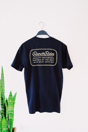 Dark blue t-shirt that has a white “Ranch Rider Spirits Co.” design on the back.