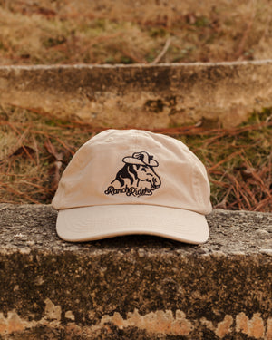 Khaki baseball cap with an embroidered design of a horse wearing a cowboy hat and the words “Ranch Rider” below the horse.