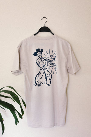 T-shirt with an illustration of a cowboy holding a sign that says “It’s a Ranch Rider Hoedown!” on the back.