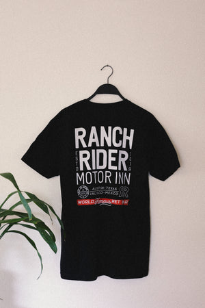 Black t-shirt with the words “Ranch Rider Motor Inn, Austin, Texas, Jalisco, Mexico, World-Famous Wet Bar.” on the back in white.