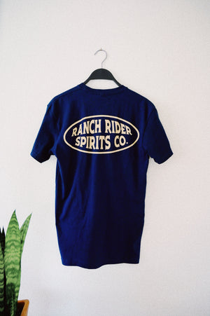 Dark blue t-shirt that has a white oval on the back with the words “Ranch Rider Spirits Co.”